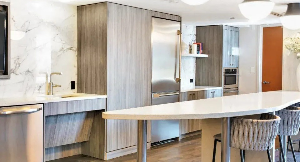 Spacious resident kitchen and lounge area with a long breakfast bar, modern appliances, and stylish seating at Kingsbury Plaza in Chicago