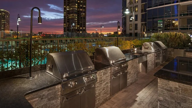 Kingsbury Plaza rooftop grilling stations illuminated at night, perfect for outdoor dining with city lights