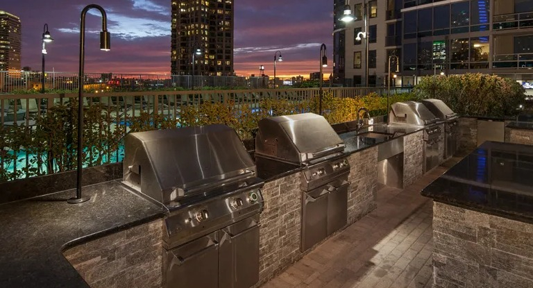 Kingsbury Plaza rooftop grilling stations illuminated at night, perfect for outdoor dining with city lights
