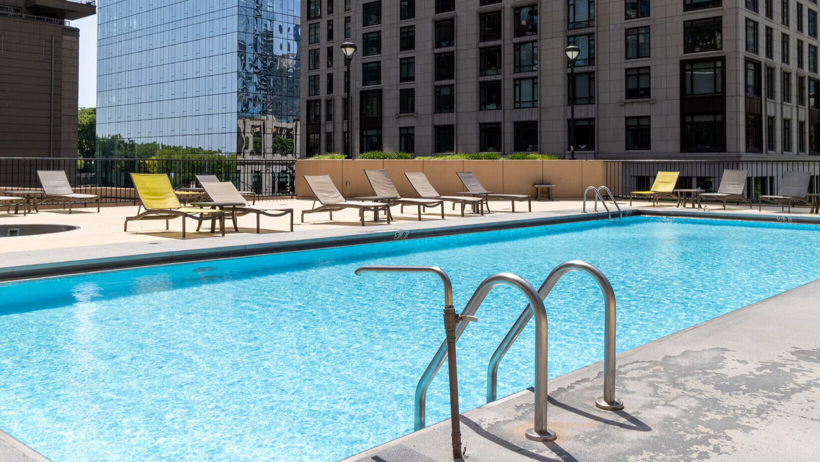 Beautiful outdoor swimming pool and sundeck with lounge chairs and privacy walls at Lake Shore Plaza apartments in Chicago