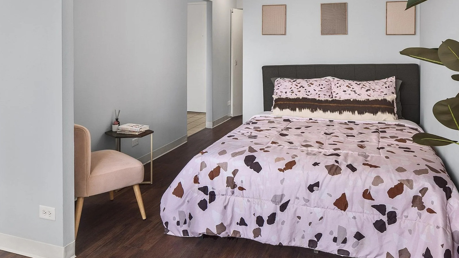 Cozy apartment bedroom at Lake Shore Plaza in Chicago, featuring a comfortable bed with colorful bedding and stylish minimal decor