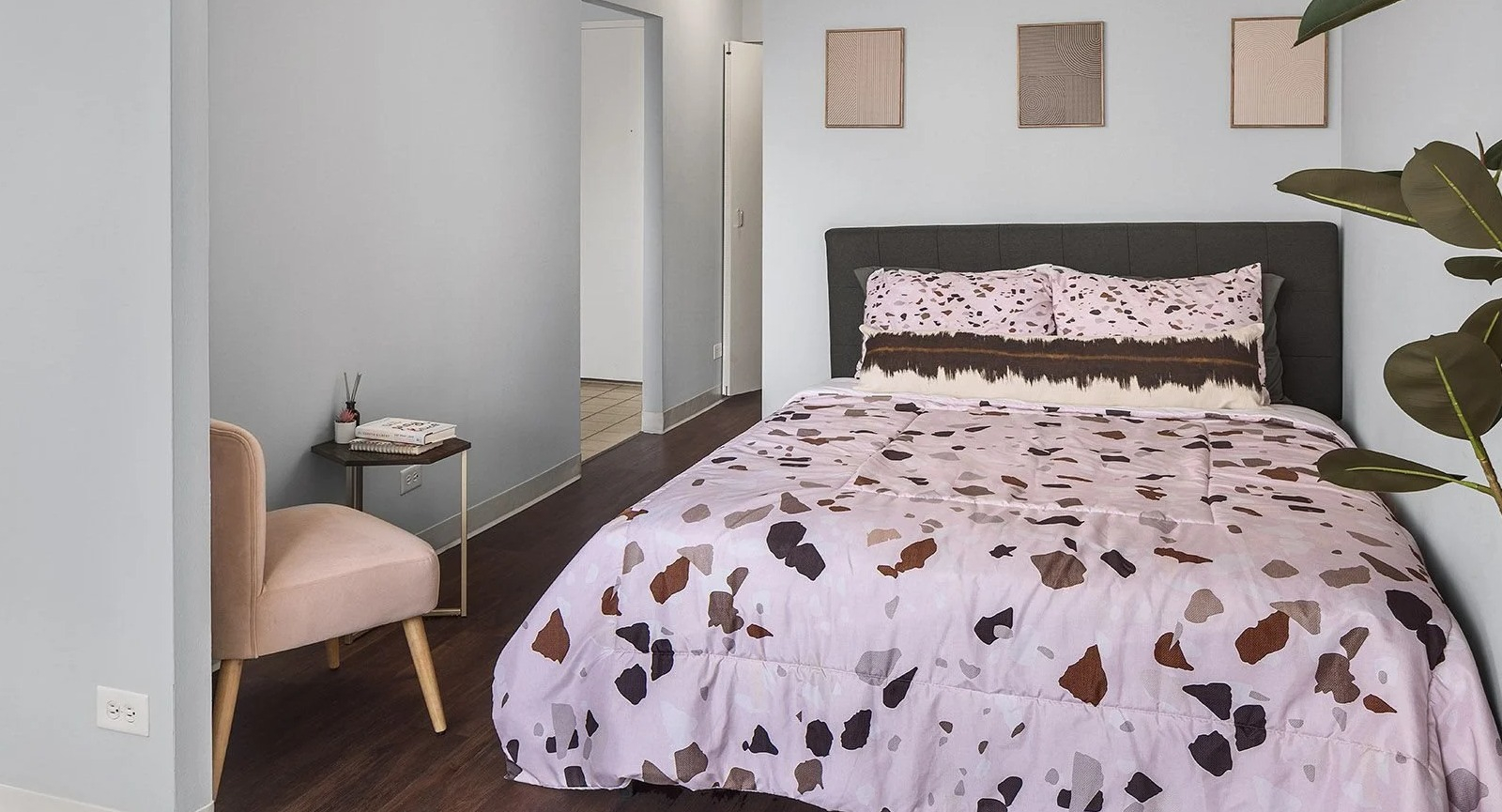 Cozy apartment bedroom at Lake Shore Plaza in Chicago, featuring a comfortable bed with colorful bedding and stylish minimal decor