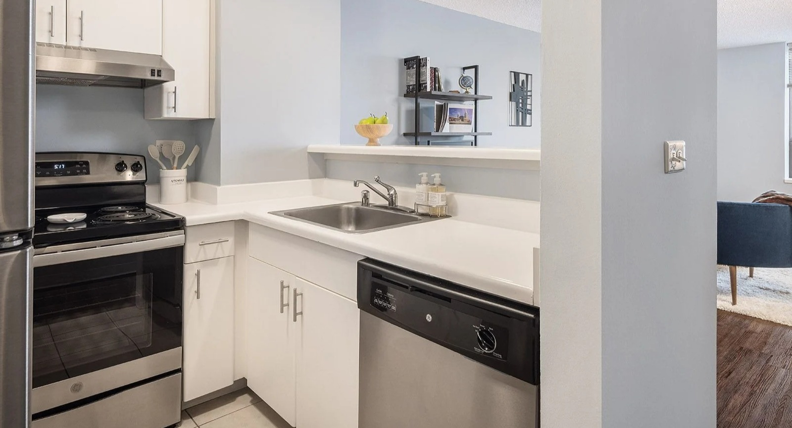 Modern apartment kitchen at Lake Shore Plaza in Chicago, with stainless steel appliances and an open view into the inviting living area
