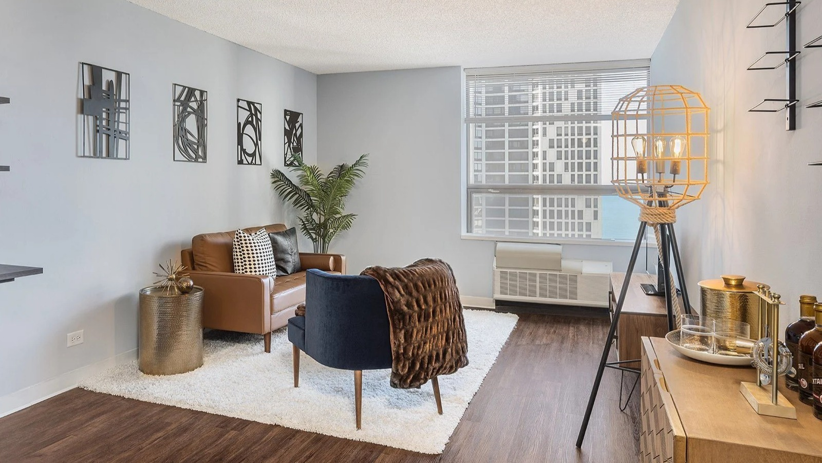 Stylish apartment living room at Lake Shore Plaza in Chicago, featuring modern furniture, unique decor, and large windows with city views