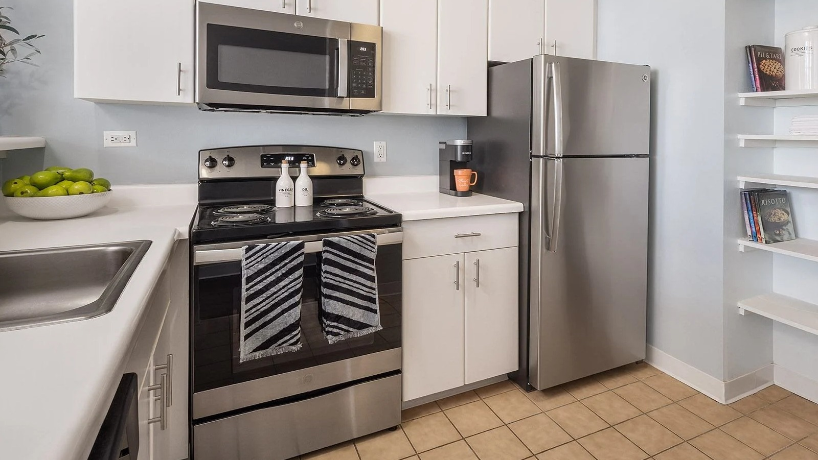 Modern apartment kitchen at Lake Shore Plaza in Chicago, with stainless steel appliances, white cabinetry, and convenient shelving
