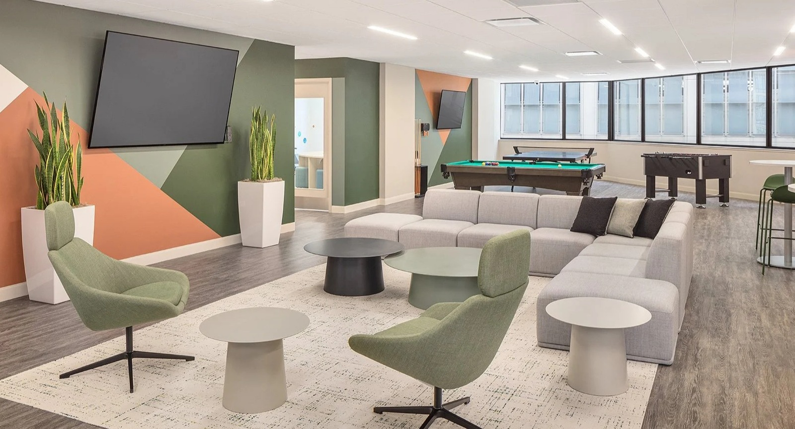Vibrant resident game lounge with a pool table, shuffleboard, and comfortable seating at Lake Shore Plaza Chicago