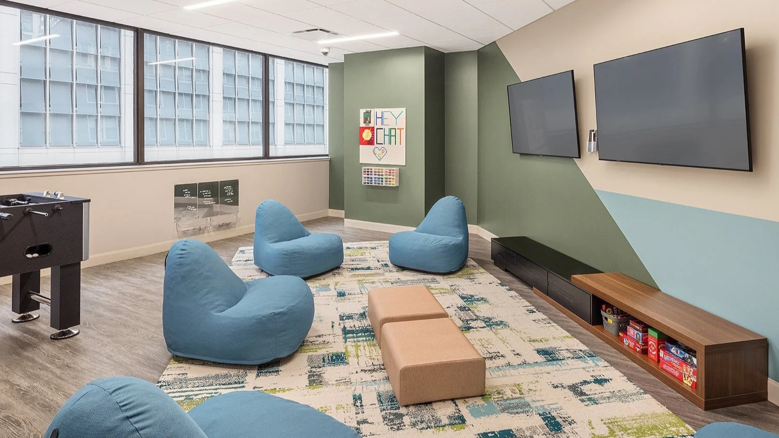 Fun teen game room with foosball, soft seating, and large screen TVs for entertainment at Lake Shore Plaza Chicago