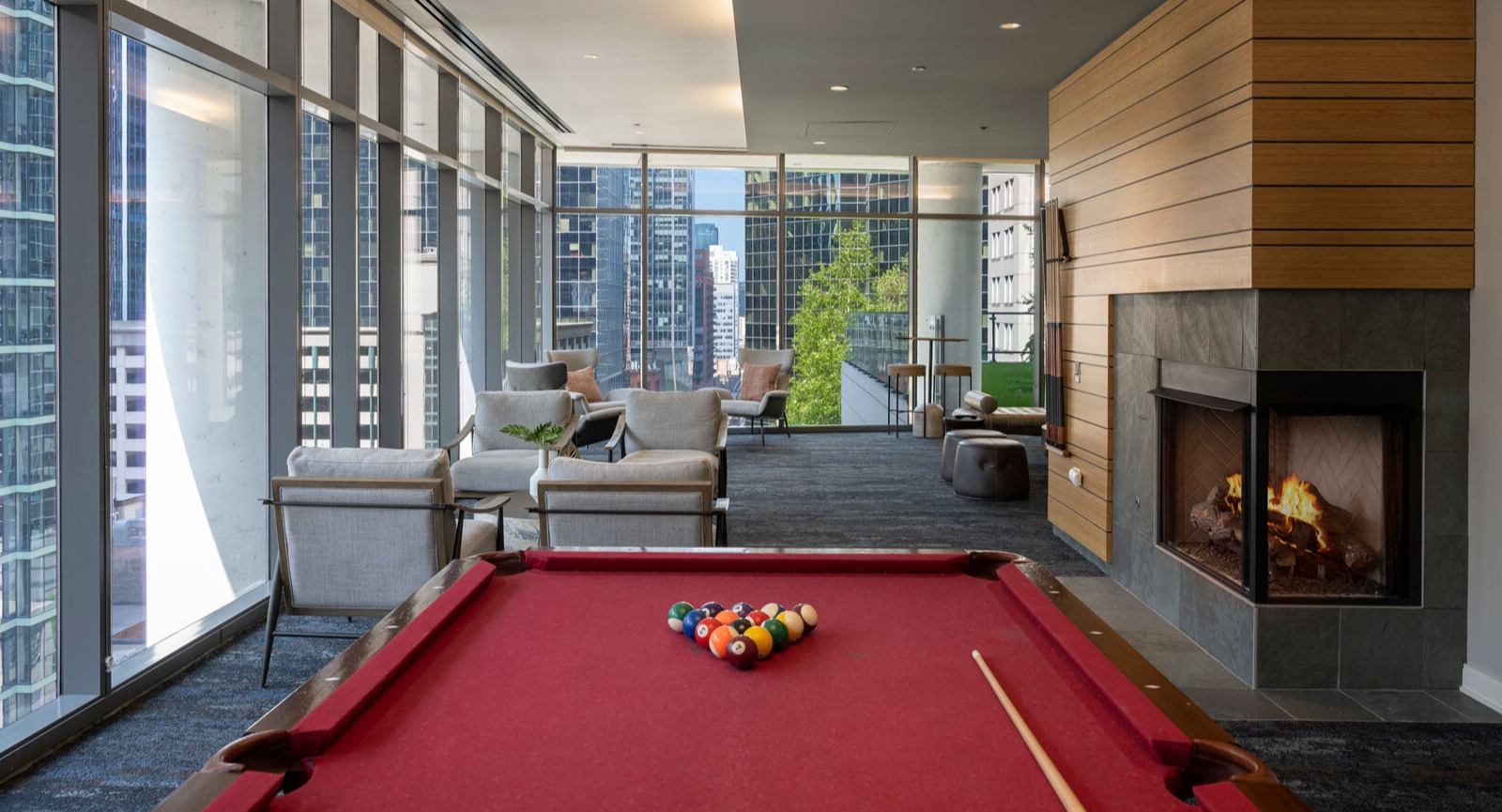 Lake & Wells game room featuring a billiards table, cozy fireplace, and stunning city views from large windows