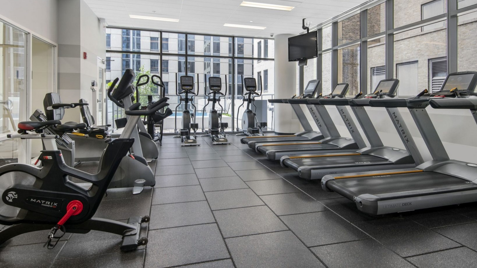 Lake & Wells gym with treadmills, ellipticals, and spin bikes, offering various cardio workout options for residents
