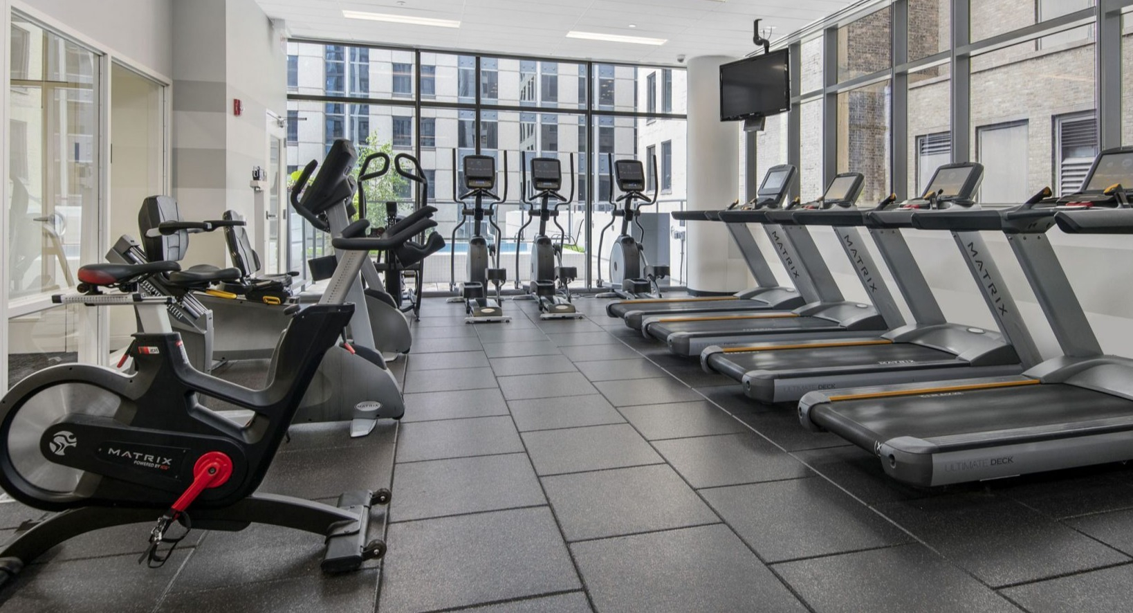 Lake & Wells gym with treadmills, ellipticals, and spin bikes, offering various cardio workout options for residents
