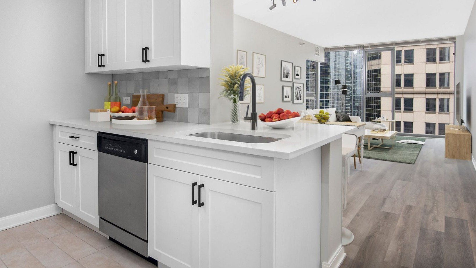 Lake & Wells apartment featuring a sleek, white kitchen with modern appliances, open to the living area