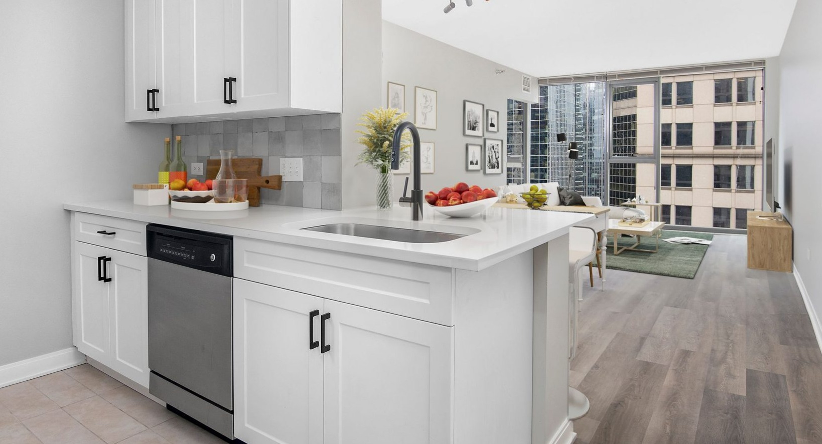 Lake & Wells apartment featuring a sleek, white kitchen with modern appliances, open to the living area
