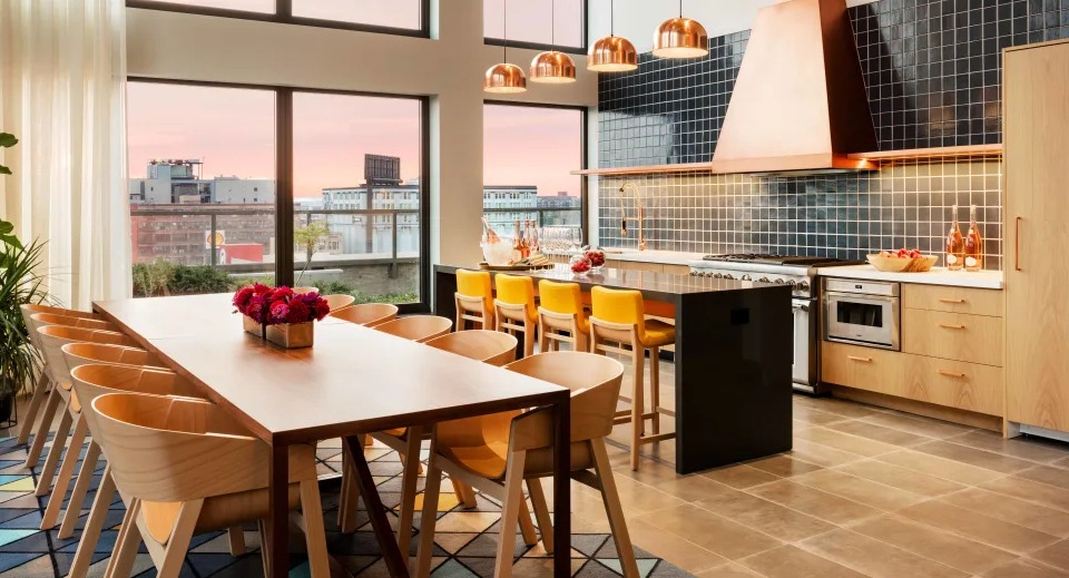 Sleek community demonstration kitchen with a spacious island, stainless steel appliances, and ample seating at Landmark West Loop