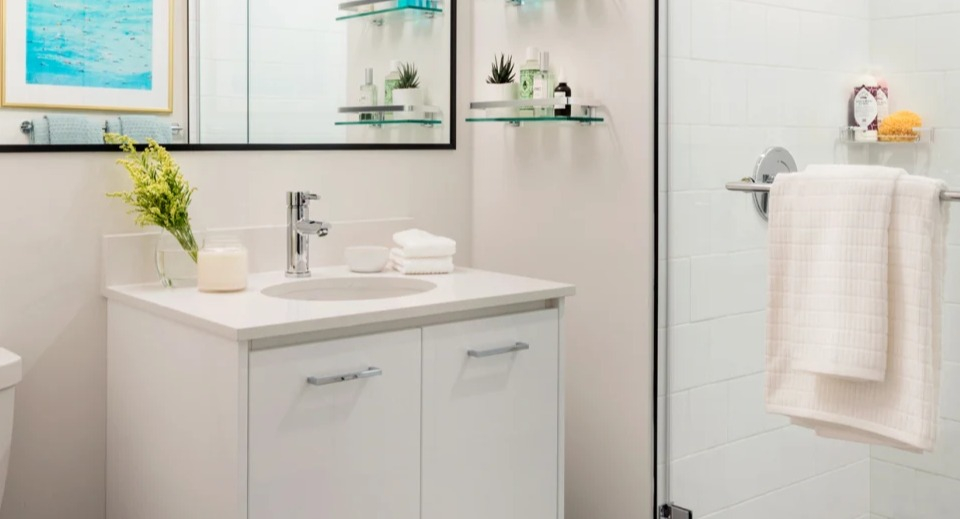 Modern apartment bathroom at Landmark West Loop in Chicago, featuring a spacious glass shower, sleek vanity, and dark hexagonal floor tiles