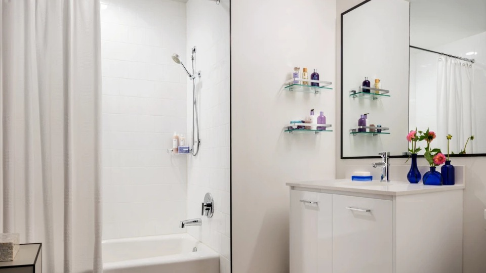 Modern apartment bathroom at Landmark West Loop in Chicago, featuring a clean white bathtub with shower and a stylish vanity