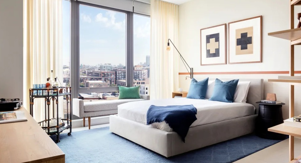 Bright and inviting bedroom with a large window offering city views, featuring modern furniture at Landmark West Loop in Chicago