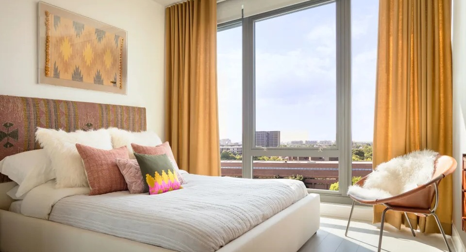 Elegant apartment bedroom at Landmark West Loop in Chicago, featuring a large bed, stylish decor, and floor-to-ceiling windows with ample natural light