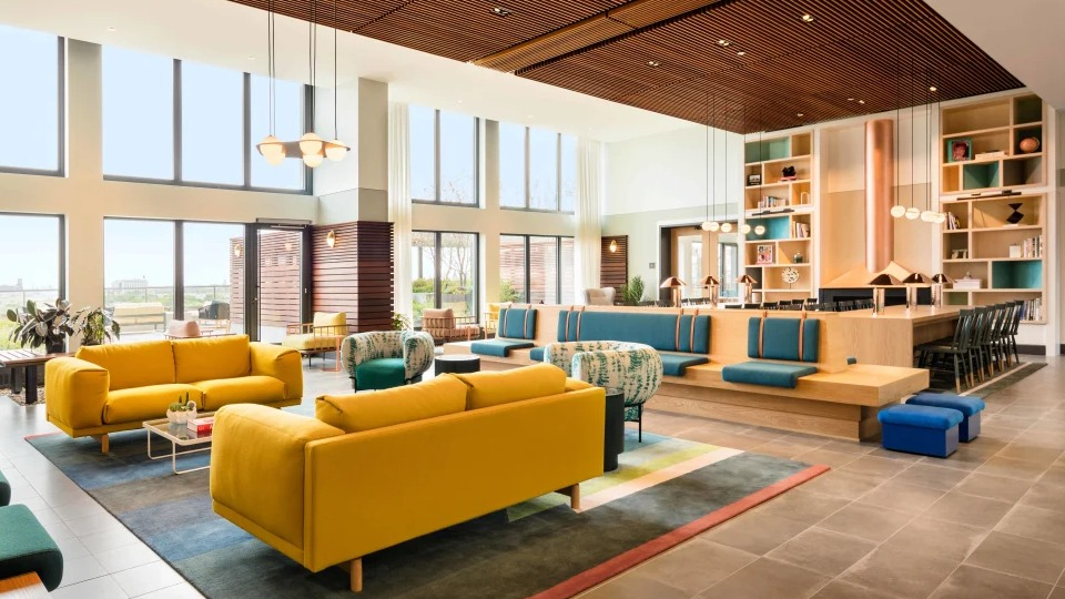Elegant resident living library and co-working space featuring comfortable seating and wall-to-wall bookshelves at Landmark West Loop