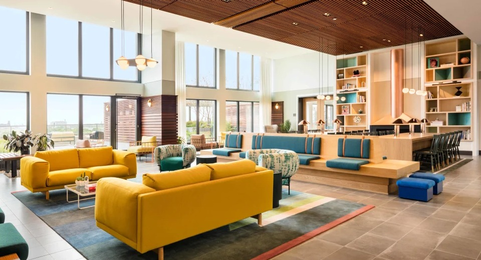 Elegant resident living library and co-working space featuring comfortable seating and wall-to-wall bookshelves at Landmark West Loop