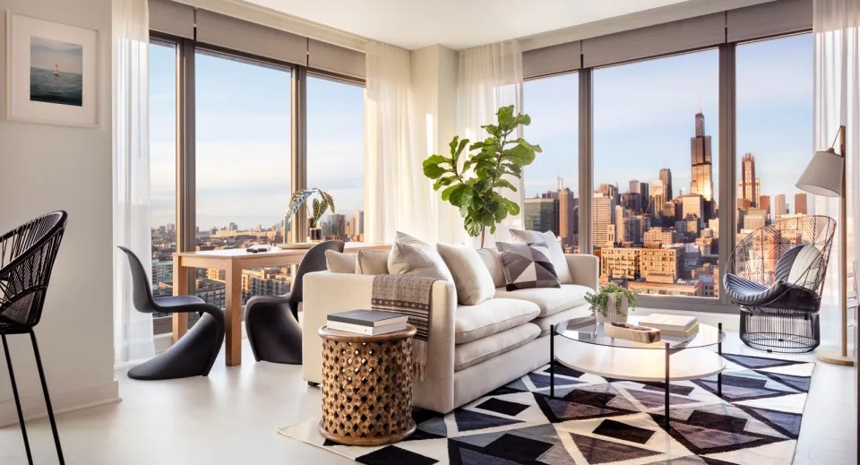 Spacious corner living room at Landmark West Loop in Chicago, featuring comfortable seating, modern rug, and panoramic city views