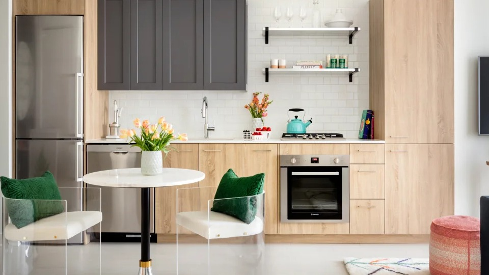 Stylish apartment kitchen and dining area at Landmark West Loop in Chicago, with two-tone cabinetry, stainless steel appliances, and modern seating