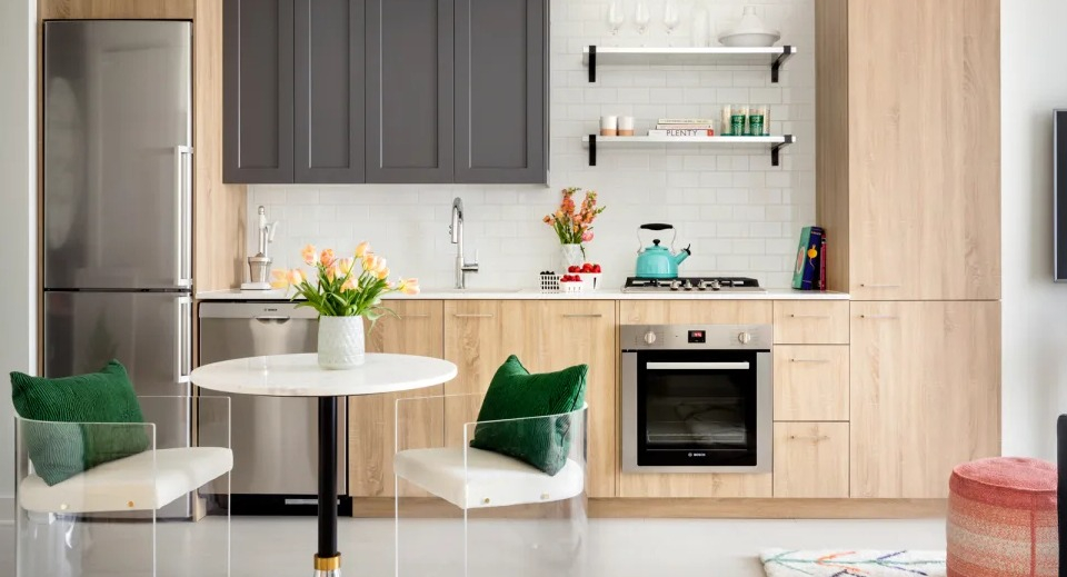 Stylish apartment kitchen and dining area at Landmark West Loop in Chicago, with two-tone cabinetry, stainless steel appliances, and modern seating