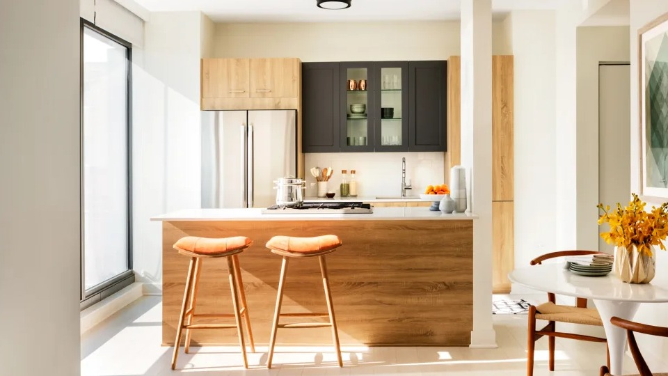 Open-concept apartment kitchen at Landmark West Loop in Chicago, with a large island, modern bar stools, and a cozy dining nook