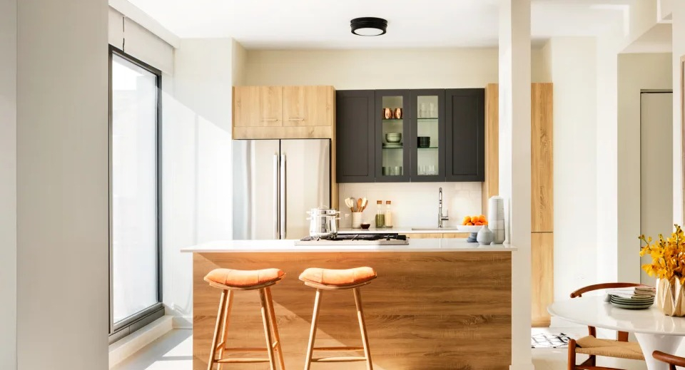 Open-concept apartment kitchen at Landmark West Loop in Chicago, with a large island, modern bar stools, and a cozy dining nook