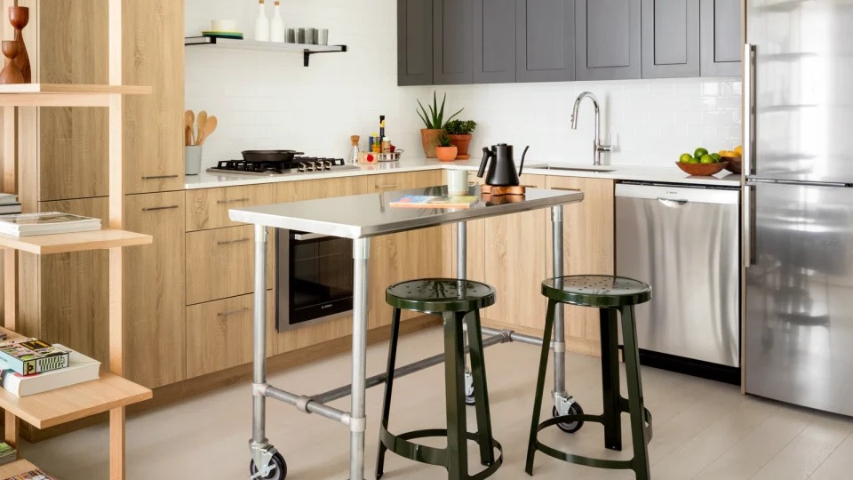 Modern kitchen with wood and grey cabinetry, stainless steel appliances, and a movable island at Landmark West Loop in Chicago