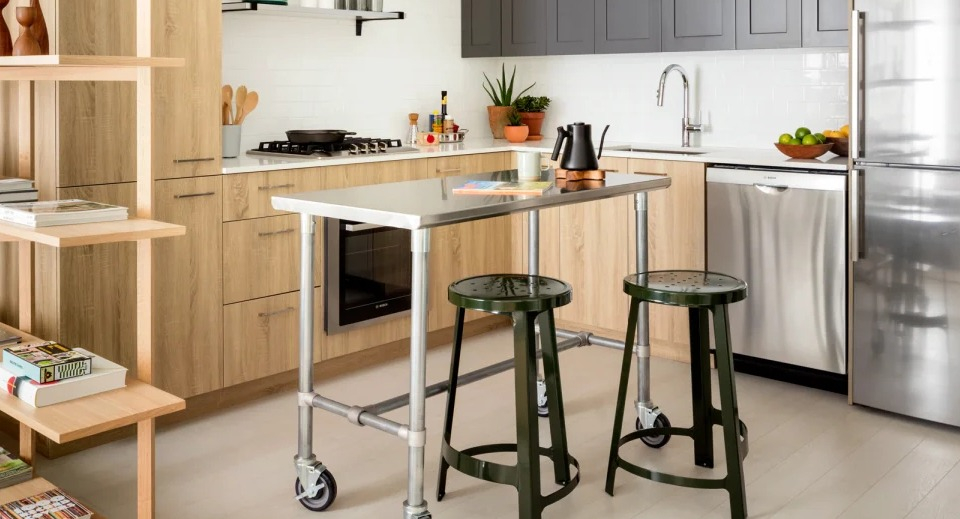 Modern kitchen with wood and grey cabinetry, stainless steel appliances, and a movable island at Landmark West Loop in Chicago