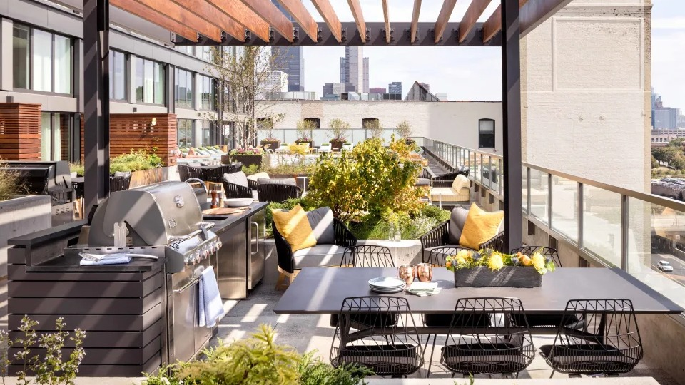 Luxurious outdoor cabana lounge area with comfortable seating and greenery at Landmark West Loop apartments in Chicago