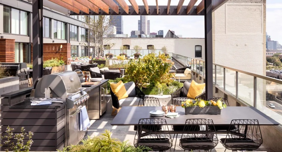 Luxurious outdoor cabana lounge area with comfortable seating and greenery at Landmark West Loop apartments in Chicago