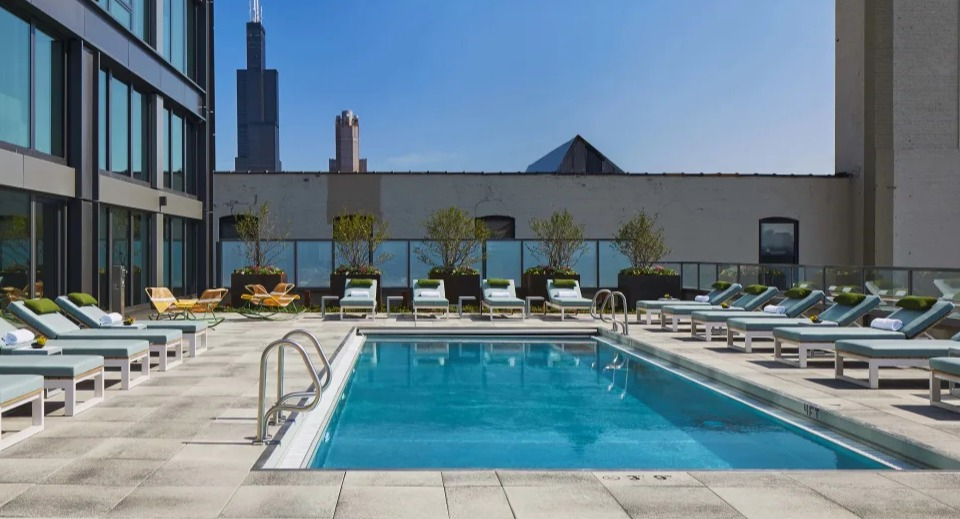 Outdoor swimming pool deck with comfortable lounge chairs and a stunning Chicago city skyline view at Landmark West Loop