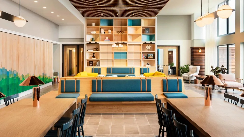 Vibrant resident lounge with diverse seating, co-working tables, and a stylish design at Landmark West Loop apartments in Chicago