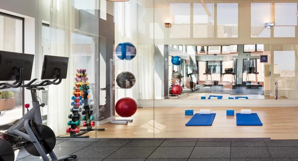 Dedicated yoga and stretching studio with bright natural light and hardwood floors at Landmark West Loop apartments in Chicago