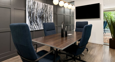 Contemporary conference room with a large table, ergonomic chairs, and a mounted TV, perfect for meetings at Left Bank in Chicago