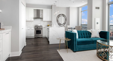 Spacious open-concept living room and kitchen area with vibrant decor and stunning city views at Left Bank apartments in Chicago