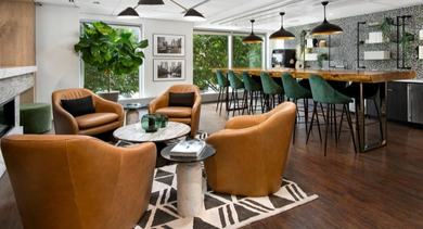 Elegant resident lounge with a cozy fireplace, bar seating, and comfortable armchairs, ideal for unwinding at Left Bank in Chicago