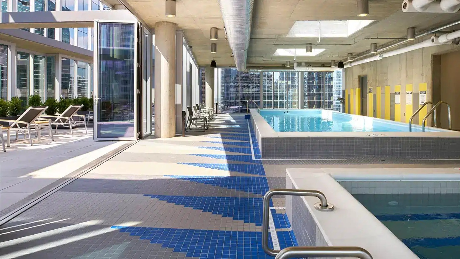 Indoor swimming pool and spa area with large windows, offering a bright and relaxing atmosphere at Linea Apartments in Chicago
