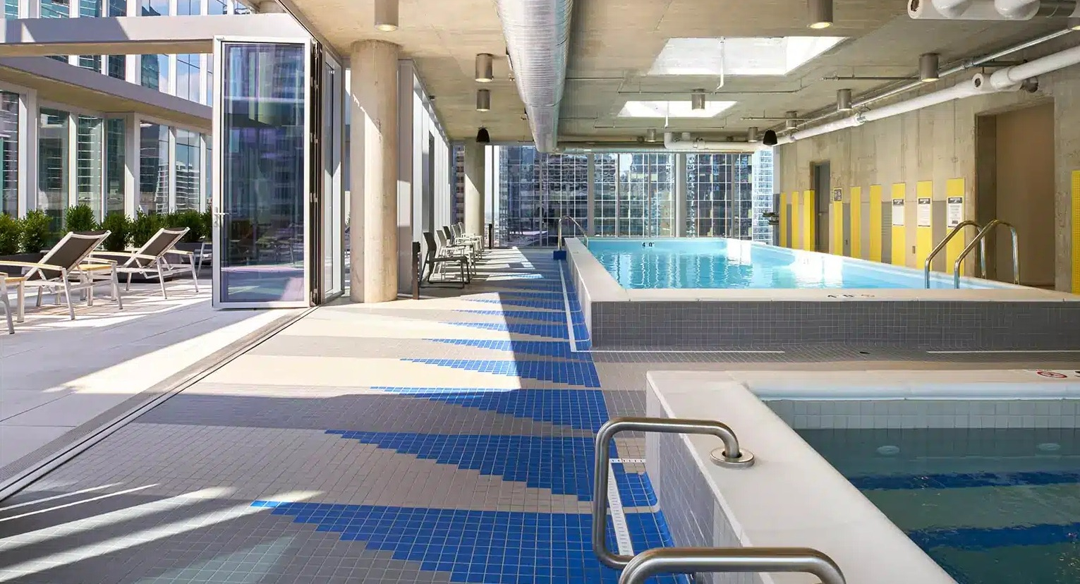 Indoor swimming pool and spa area with large windows, offering a bright and relaxing atmosphere at Linea Apartments in Chicago
