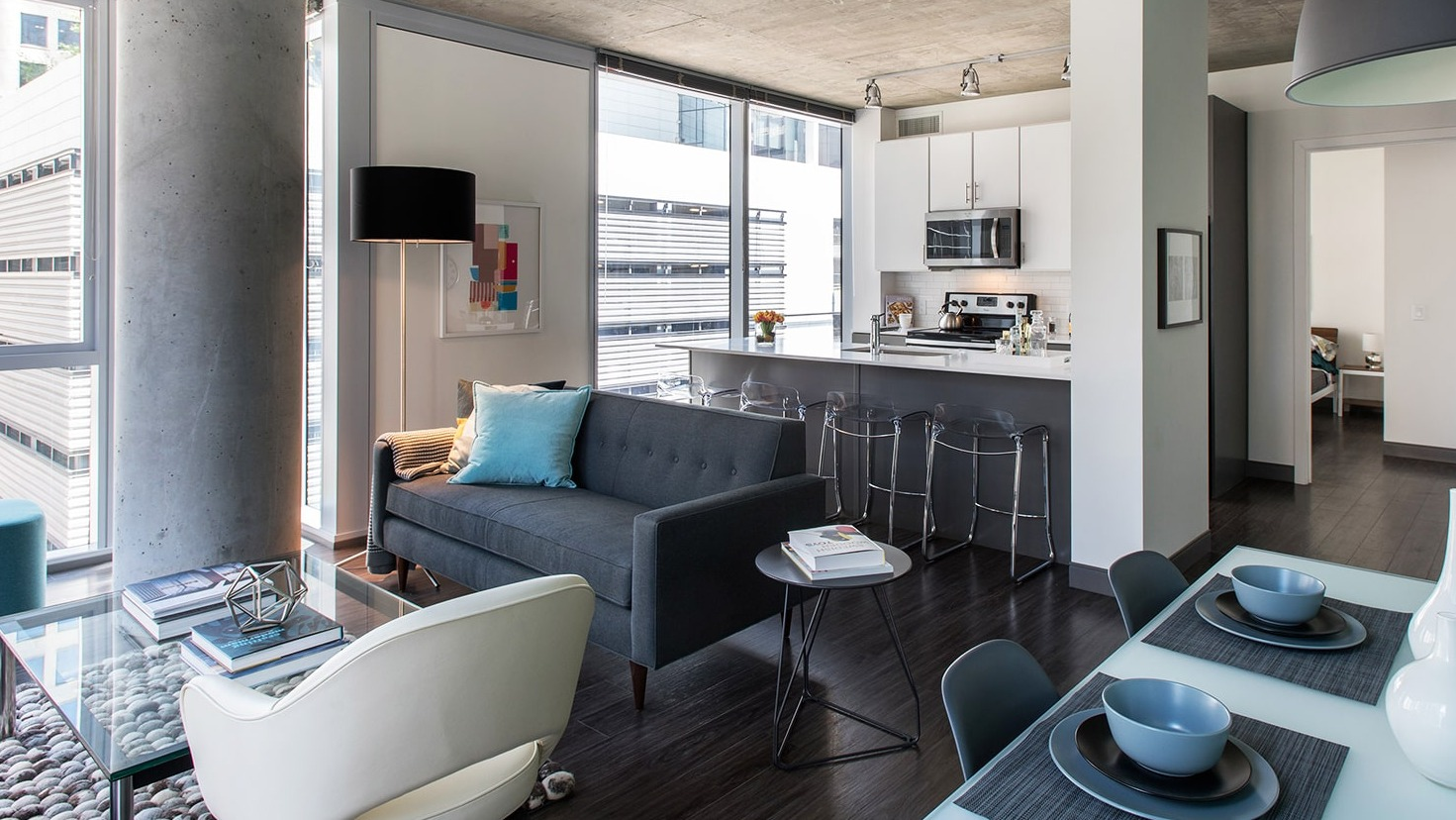 Contemporary living room flowing into a kitchen with a breakfast bar and modern design at Linea Apartments in Chicago