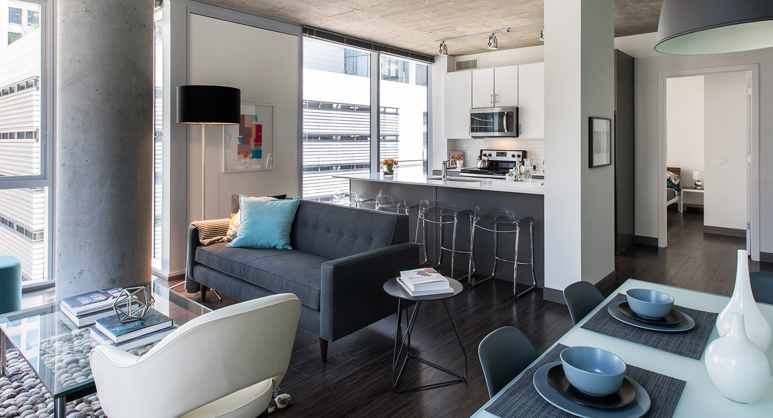 Contemporary living room flowing into a kitchen with a breakfast bar and modern design at Linea Apartments in Chicago