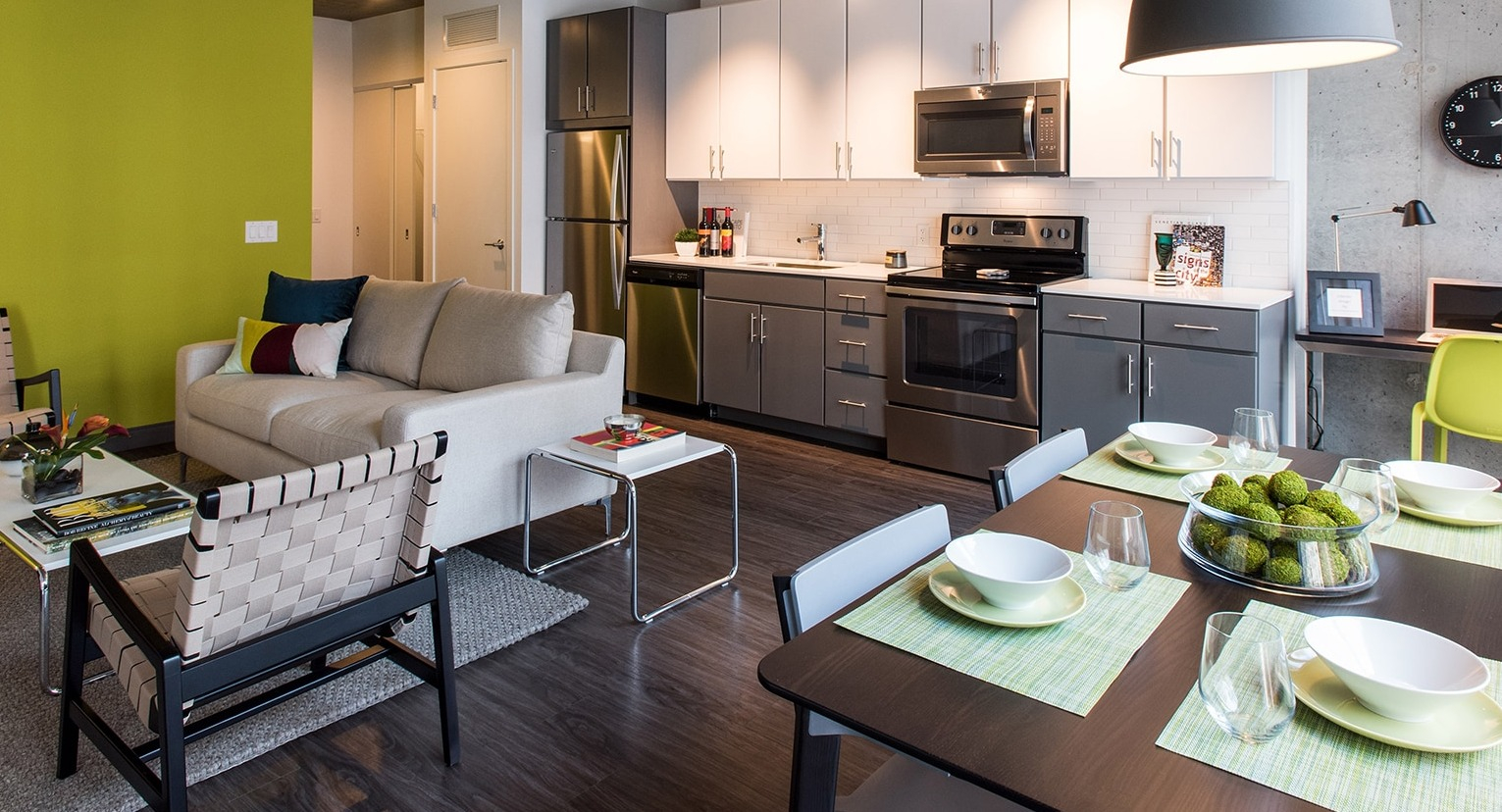 Vibrant open-concept living room and kitchen area with stylish furniture and colorful accents at Linea Apartments in Chicago