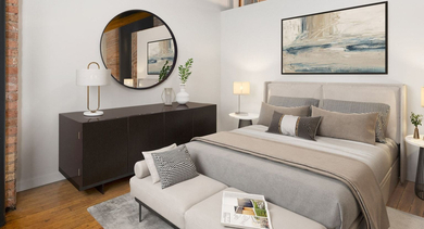 Stylish bedroom at The Lofts at Gin Alley in Chicago, featuring a comfortable bed, exposed brick, and industrial-chic accents