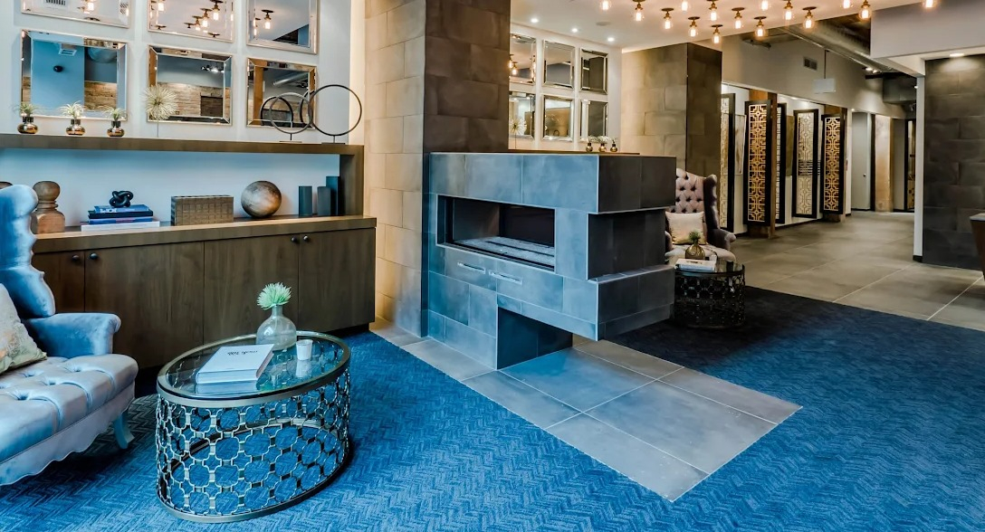 Grand lobby lounge with a modern fireplace, stylish seating, unique lighting, and a vibrant blue carpet at Lofts at River East in Chicago