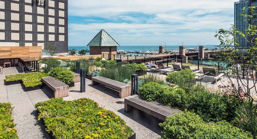 Expansive rooftop lounge area with outdoor seating, green spaces, and panoramic views of the Chicago River and city skyline at Lofts at River East in Chicago
