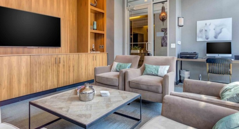 A versatile resident lounge at Luxe on Chicago Apartments, combining comfortable seating with a dedicated work area and computer