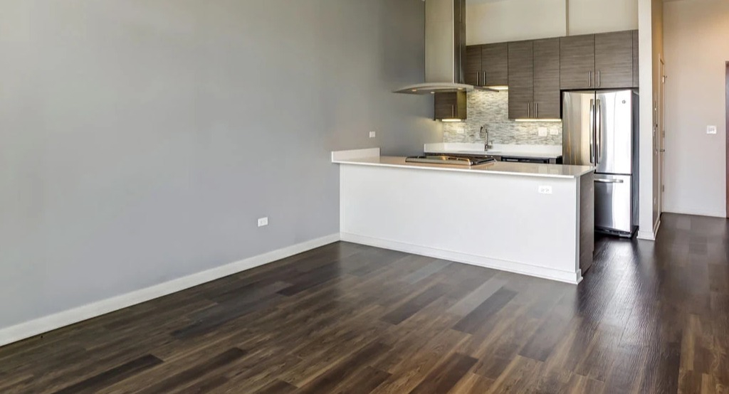 Open-concept kitchen and living area at Luxe on Madison Apartments in Chicago, featuring a sleek kitchen island
