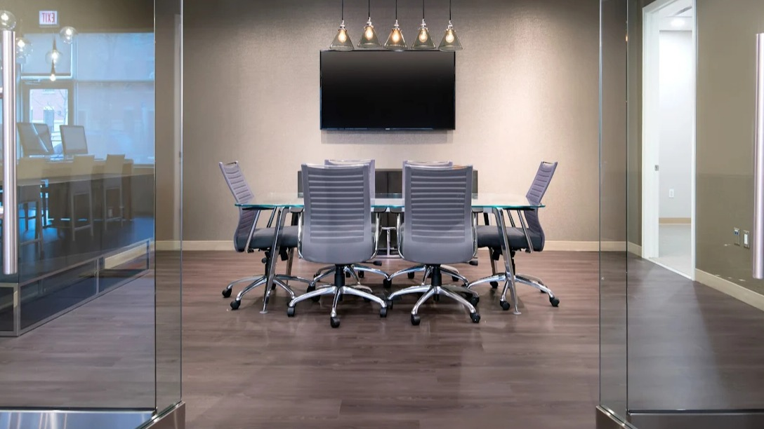 Chic meeting room at Luxe on Madison Apartments in Chicago with a large screen and comfortable chairs