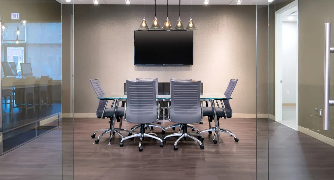 Chic meeting room at Luxe on Madison Apartments in Chicago with a large screen and comfortable chairs
